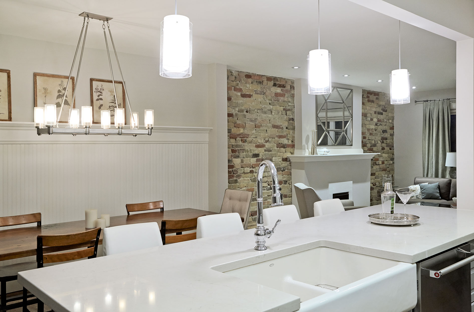 Light-filled kitchen with a generous island, pendant lighting, and exposed brick